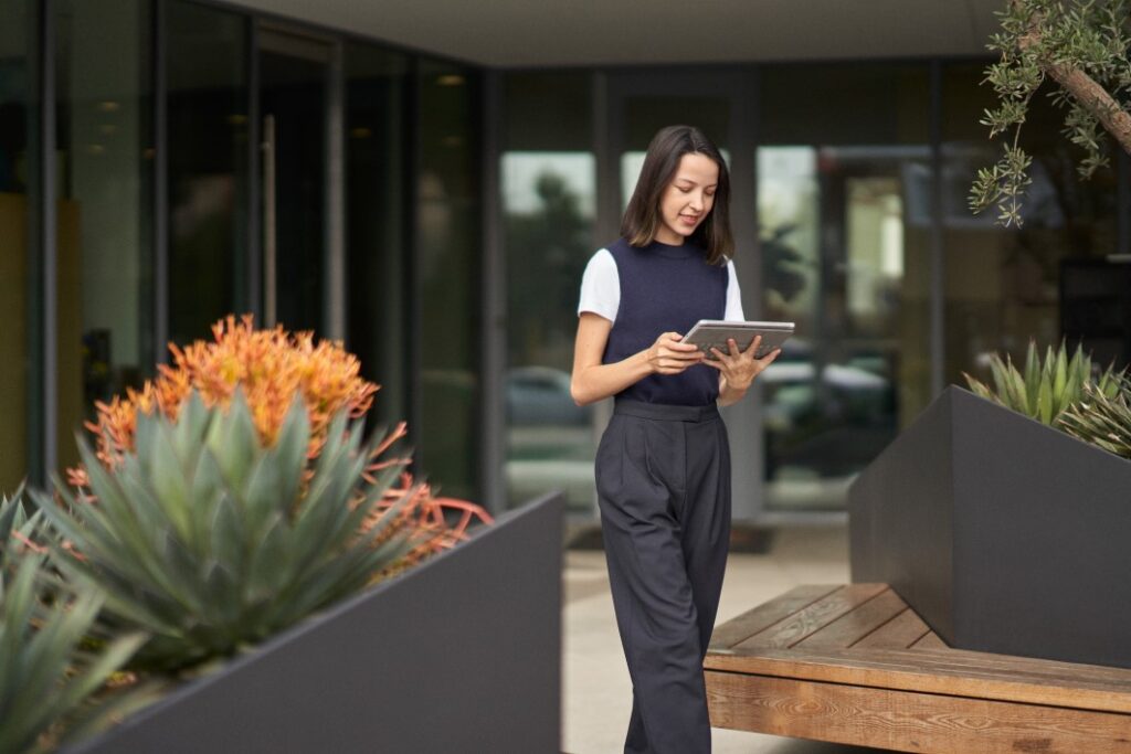 A woman participating in a Microsoft Teams meeting on her Surface tablet while on the go.