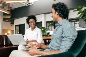 Two entrepreneurs relax in a casual office and discuss strategy.