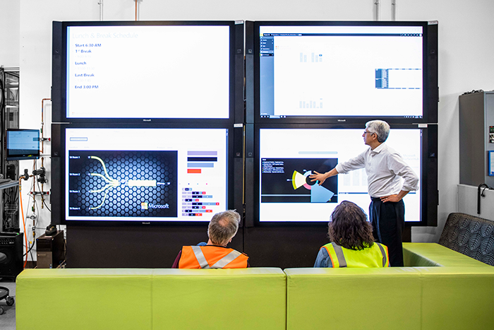 複数画面を活用して製造工程を確認する男女