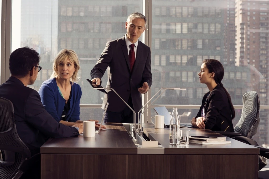 会議室で打ち合わせをする男女 4 人