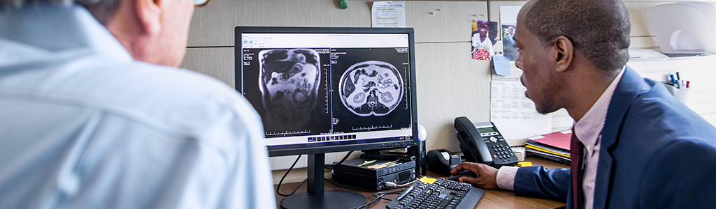 Dos personas mirando imágenes médicas en una computadora