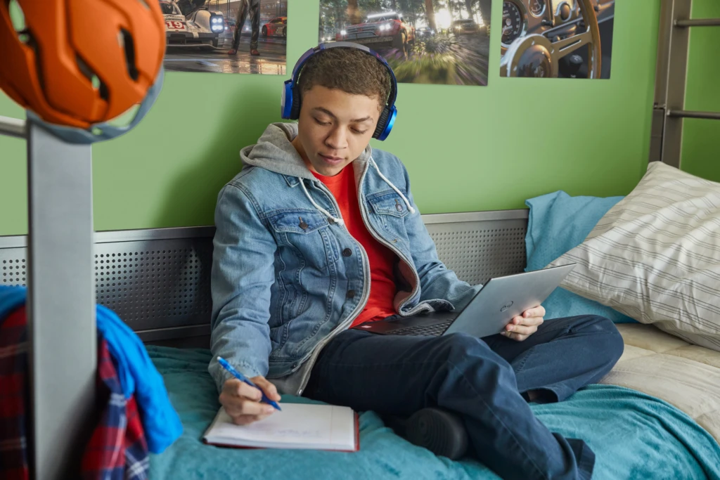 Auf dem Fotos sieht man einen Jungen, der ein Device benutzt.