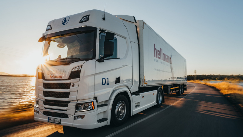 Ein LKW fährt auf einer Straße Autobahn neben einem Gewässer.