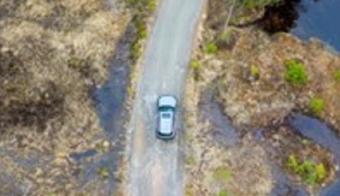 Ein Auto fährt auf einer Straße. Vogelperspektivenansicht.