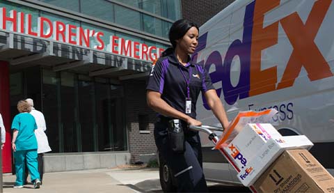 A woman delivering packages in front of a hospital