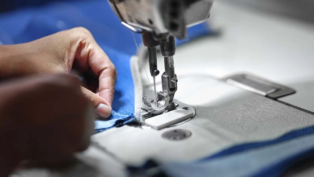 Nahaufnahme wie eine Person mit einer Nähmaschine näht.