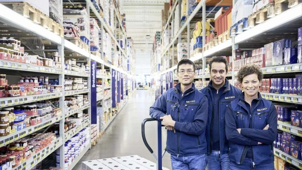 Drei Metro Mitarbeiter stehen in einem Gang in einem Metro Großmarkt