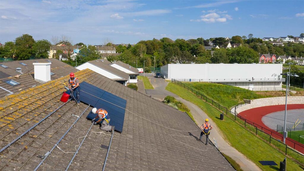 Techniker installieren Solarpanel auf einem Dach. 