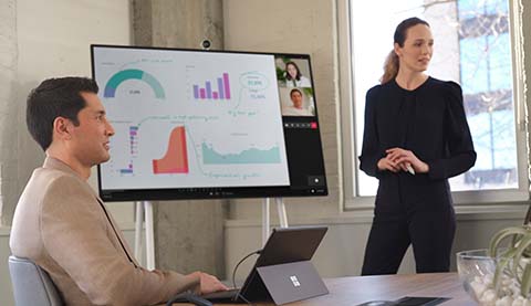 Mann und Frau vor einem großen digitalen Presenter-Board. 