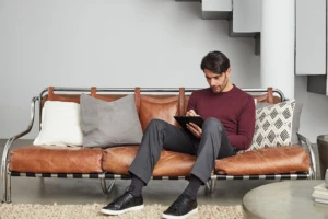 Man working inside his home writing with digital pen, on his own device via a BYOD policy