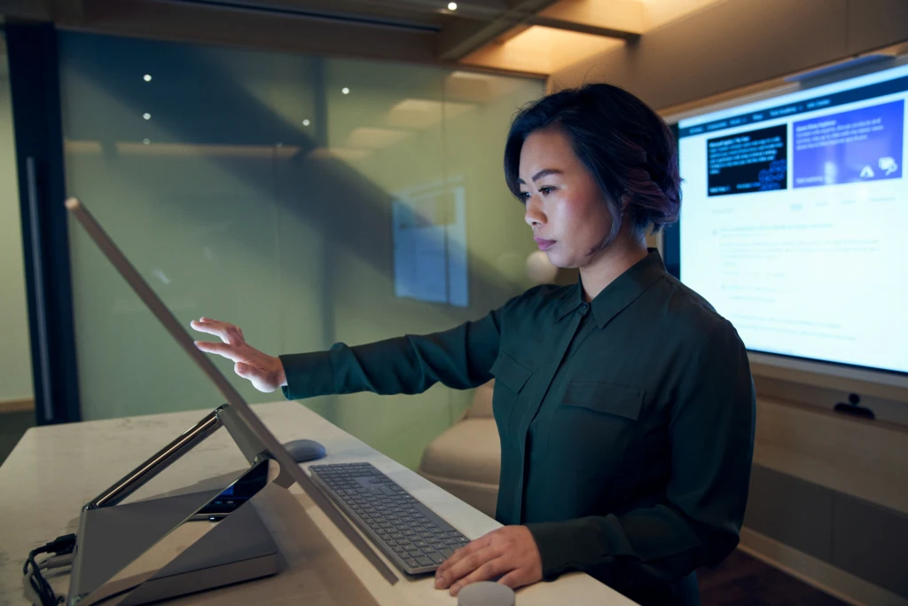 Cyber resilience includes building teams with the skills to secure your data, and using technology to assist. A female cybersecurity employee works in an office.