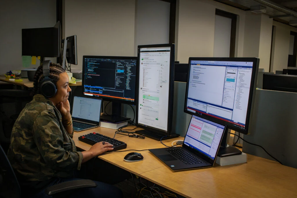 A female developer sitting behind a desk coding