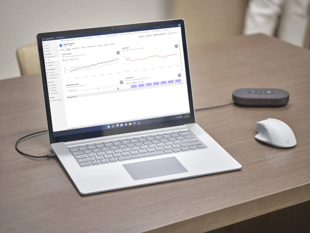 Desk scene wih a Surface Laptop 4 with Dynamics 365 on the screen, a Modern USB-C speaker and Microsoft Precision Mouse.