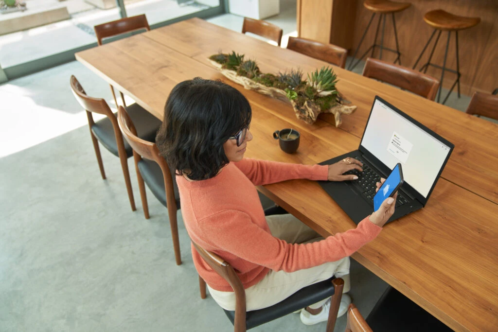 Employee using mobile phone to complete multi-factor authentication to prepare to work from home.