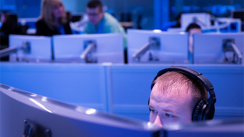 Man working while wearing headphones in the Microsoft Cyber Defense Operations Center