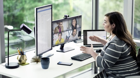 Photographie d’une personne assise à son bureau à la maison, en conférence avec des collègues sur Microsoft Teams.
