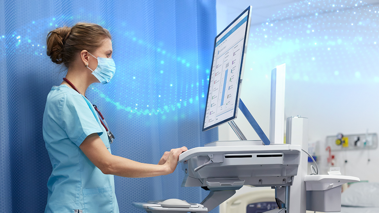 Nurse wearing a facemask working on her standing desk.