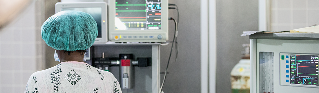 Imagem de profissional médico em frente a um aparelho conectado com fios