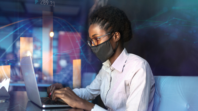 women with a mask working on laptop
