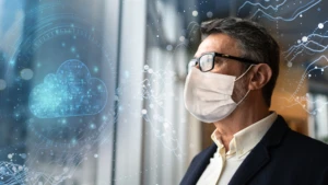 man with a face mask looking out a window