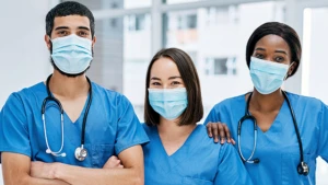 Three doctors in face masks and scrubs