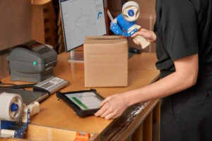 Customer service fulfilling, packaging and shipping online orders in the storeroom.