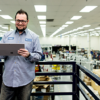 Image of a worker in a warehouse working on a tablet.