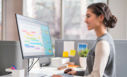 Woman using a laptop at a computer workstation