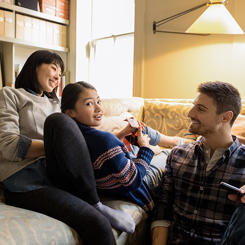 A family sitting on their couch.