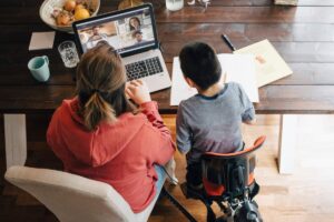 High angle view of mother and son with disabilities watching video on laptop while sitting at home