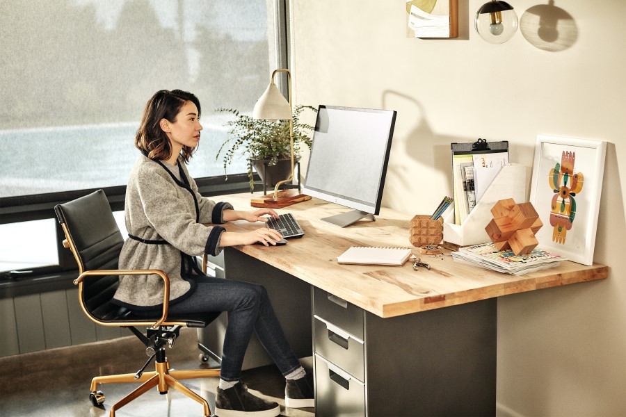 A female works on her Acer desktop computer in her bright office.