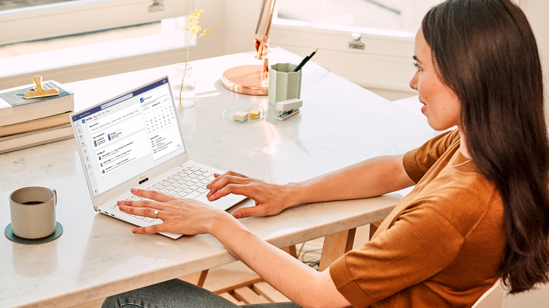 A person using a laptop with the Workday for Teams app displayed on the screen.