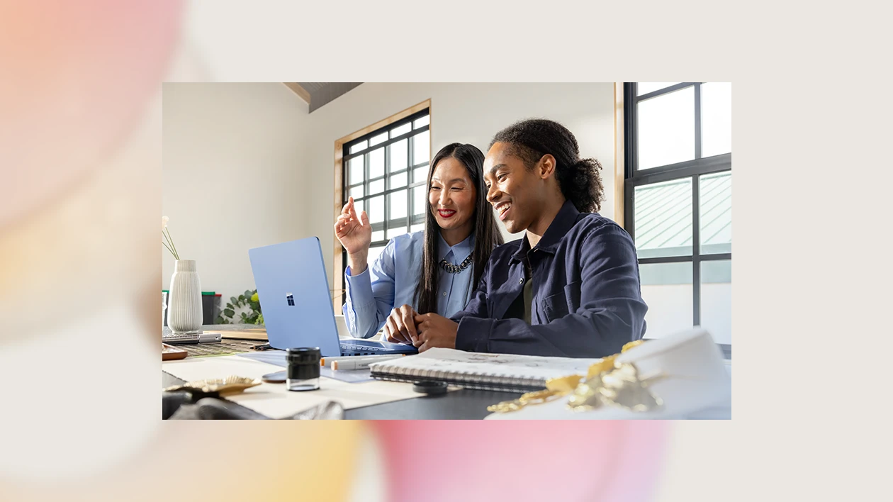 A woman and a man looking at a laptop