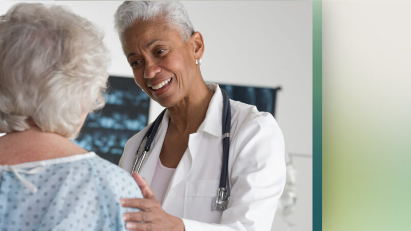 A decorative image of a healthcare worker talking to a patient