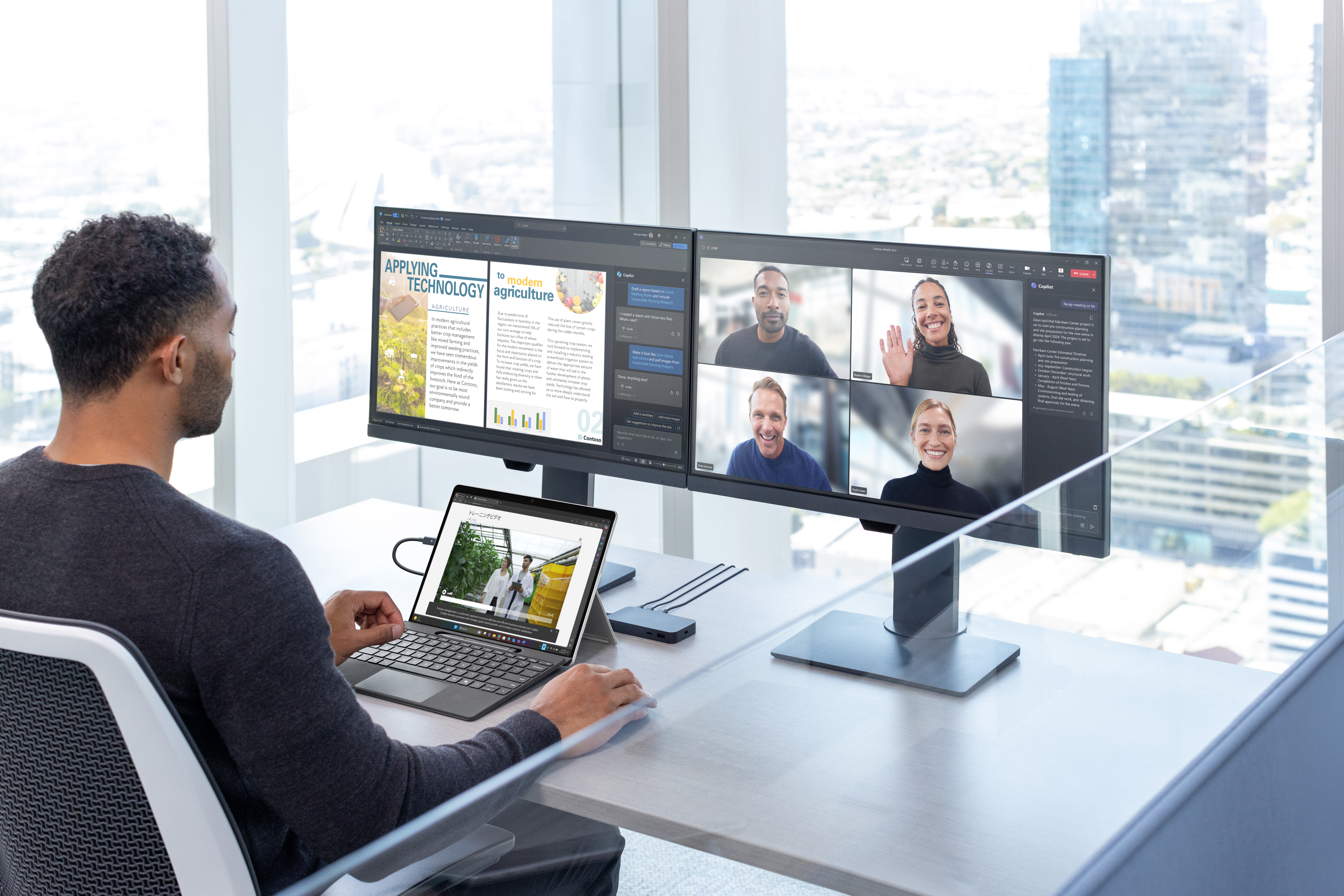 A man sitting at a desk with multiple monitors