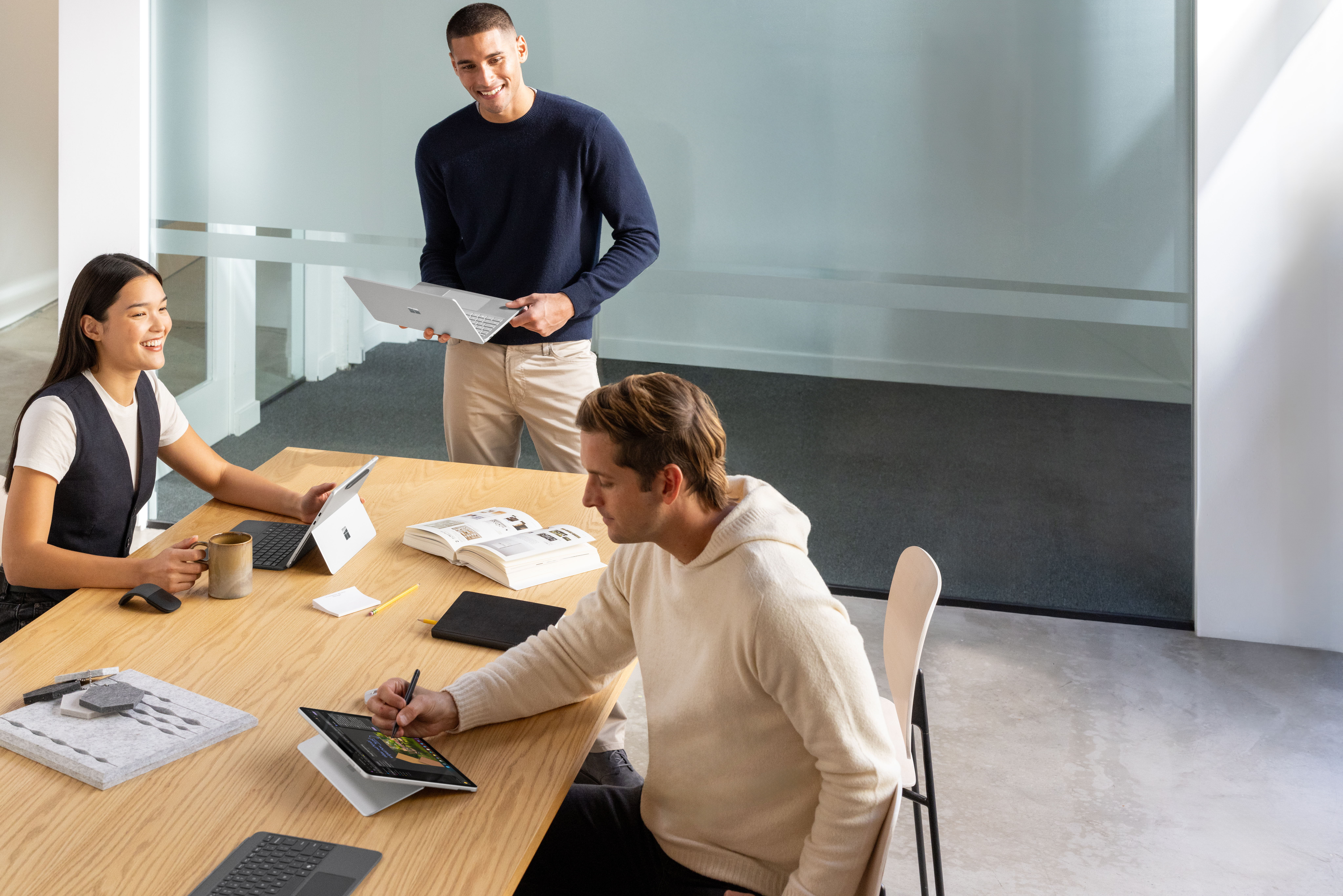 A group of people sitting at a table with laptops