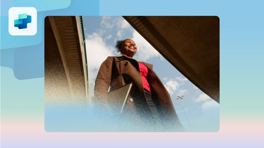 A smiling woman walking to work carrying her laptop