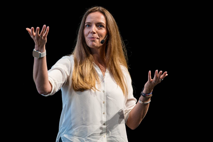 Woman giving presentation on stage with microphone