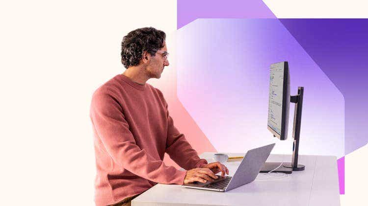 A man sitting at a desk using a laptop
