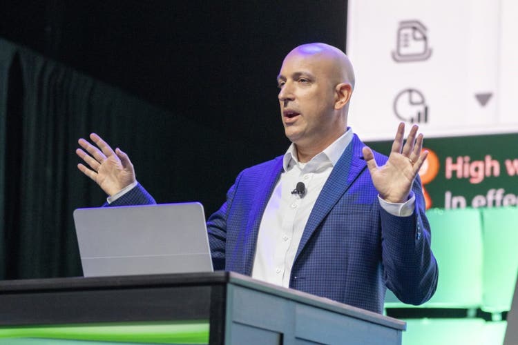 A man standing at a podium with his hands up