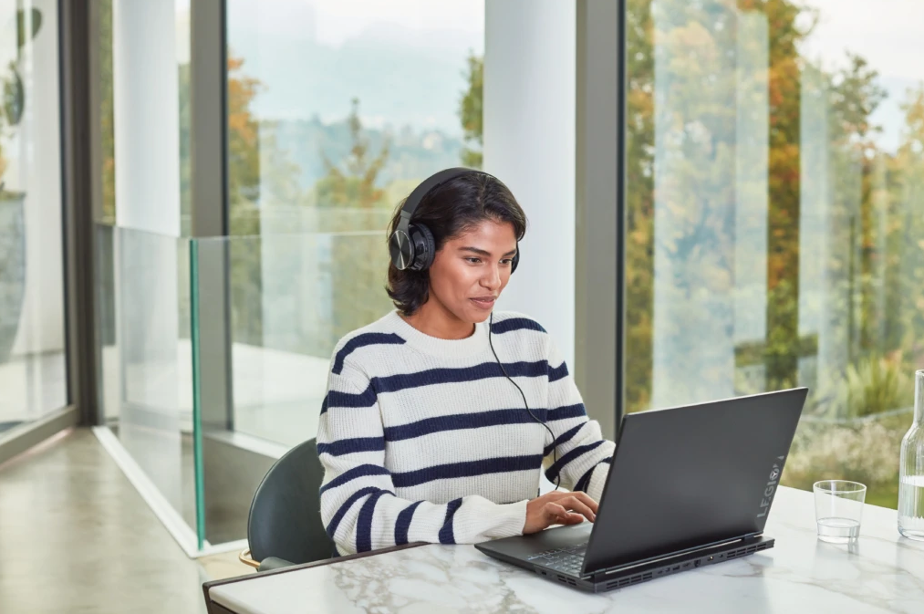 a woman sitting at a table using a laptop computer