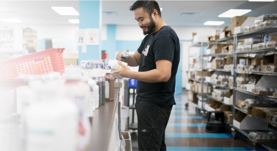 A man at a retail counter scanning an item.