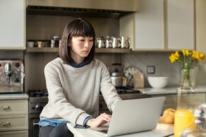 Female working on laptop in kitchen