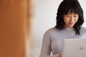 A woman engaged in focus on a laptop.