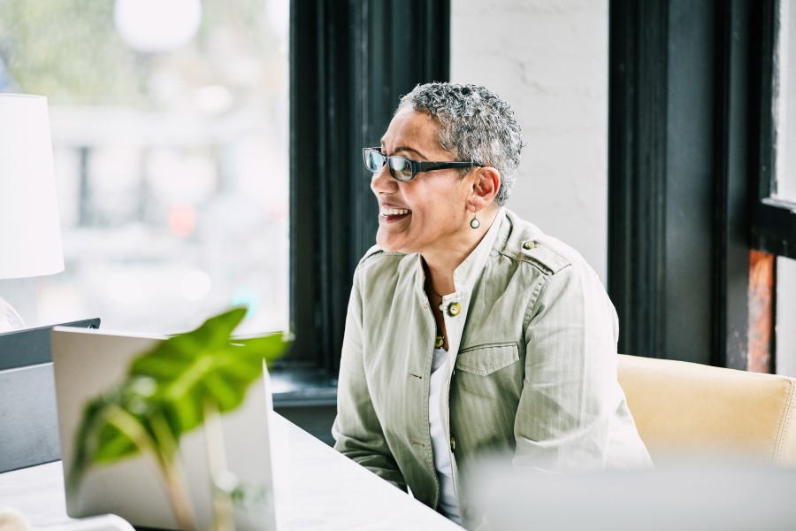 Smiling mature businesswoman working at desk in creative office