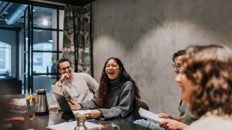 A group of people sitting at a table laughing