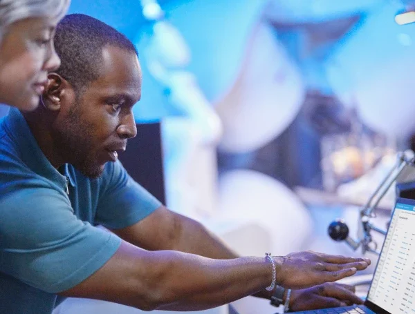 A man and woman looking at a laptop