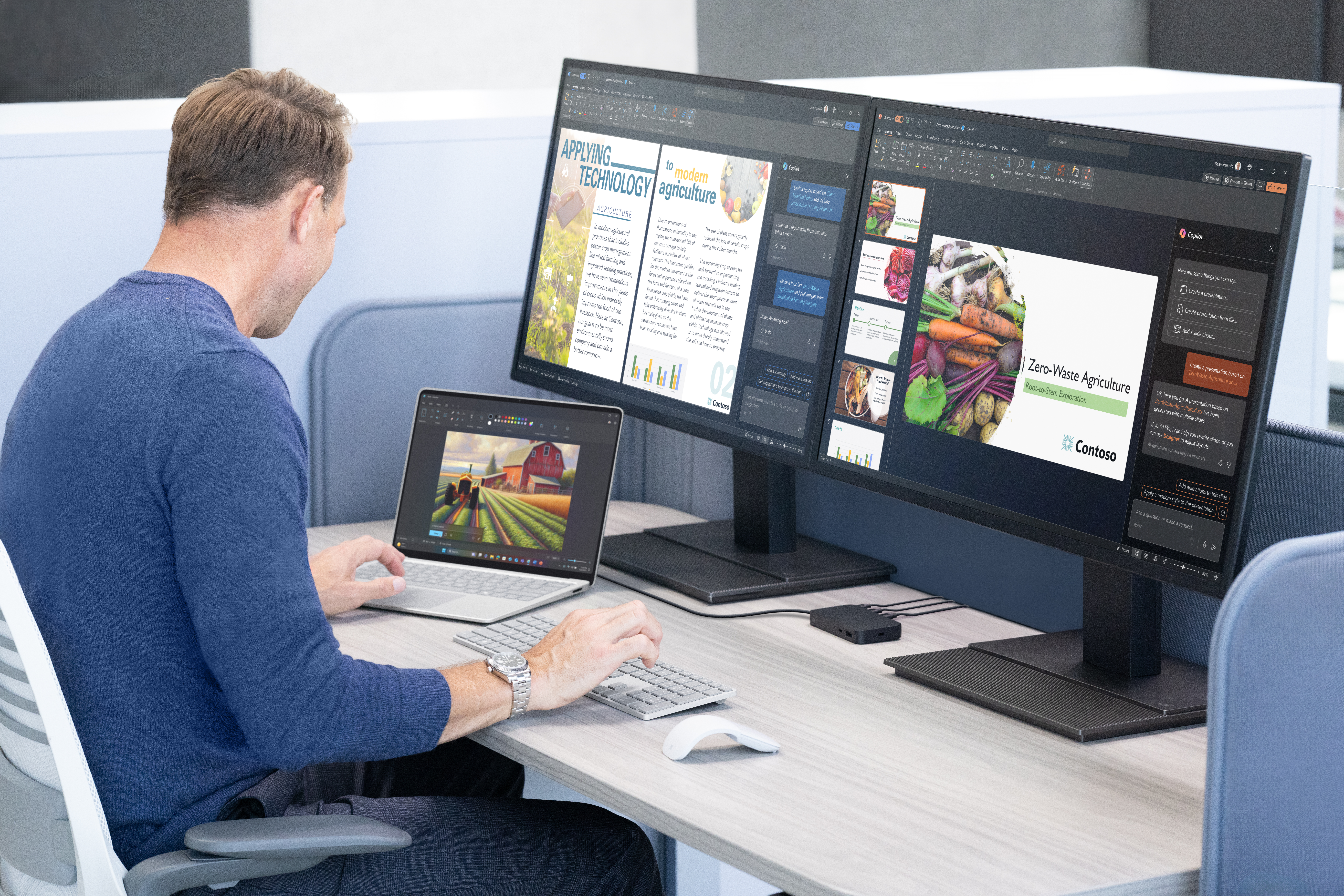 A man sitting at a desk with a laptop and a computer