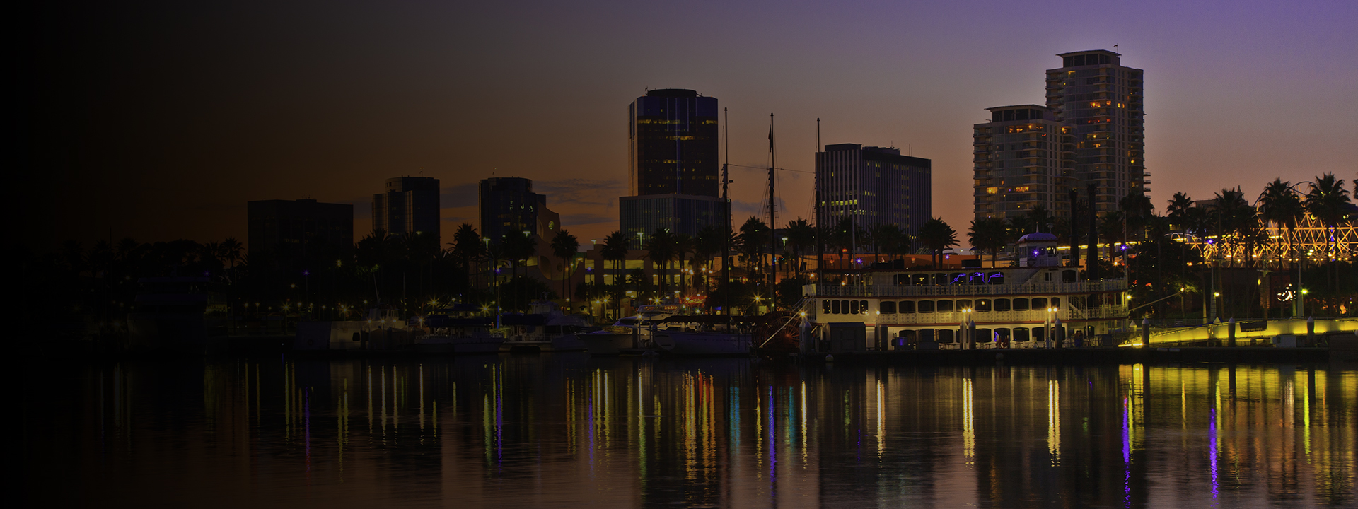 Rainbow Harbor at Long Beach Marina, California with city skyline at sunset