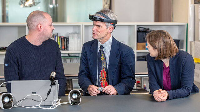 Peter Bosher（中）是一名失明的音频工程师，在设计过程的早期与东京项目团队合作，他与研究人员Martin Grayson（左）和Cecily Morrison（右）一起在英国剑桥的微软研究实验室查看了该系统的最新迭代。乔纳森·班克斯摄。